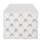 Runner Blanc Mariclò in tessuto bianco avorio con elegante ricamo a grata. All'incrocio delle linee spiccano piccoli fiocchi in rilievo color argento con dettagli sfrangiati molto raffinati.
