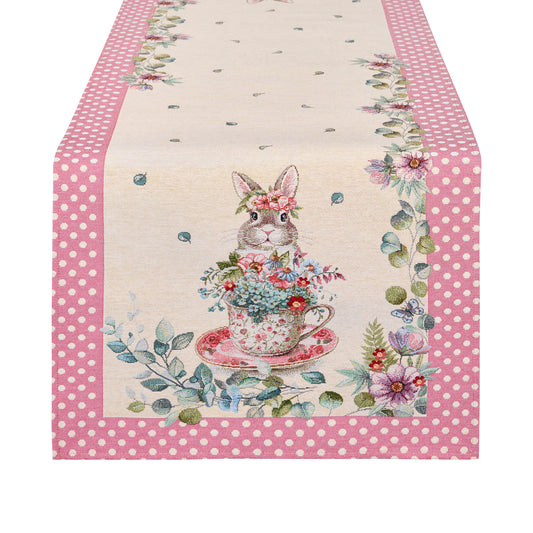 Runner pasquale EDG Enzo de Gasperi con bordo a pois rosa. Decorazione centrale con illustrazioni vintage di coniglietti, tazze da tè fiorite e farfalle. Tessuto elegante per la tavola di Pasqua 2026.