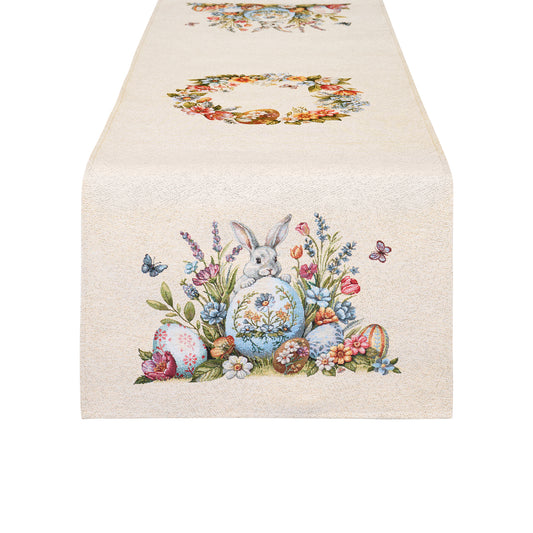 Runner pasquale Nuvole di Stoffa con bordo decorato da coniglietti, uova di pasqua, farfalle e fiori. Decorazione centrale con illustrazioni vintage di una ghirlanda di fiori. Tessuto elegante per la tavola di Pasqua 2026.