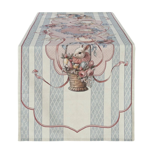 Runner da tavola della linea "Joyeuses Paques" caratterizzato da un'elegante trama a righe verticali beige e azzurre con decorazioni d'ispirazione vintage. Il pannello centrale nei toni del rosa racchiude una raffinata illustrazione pasquale con un coniglietto dentro un cesto intrecciato, uova colorate e rose, ideale per apparecchiare la tavola delle feste in perfetto stile shabby chic.