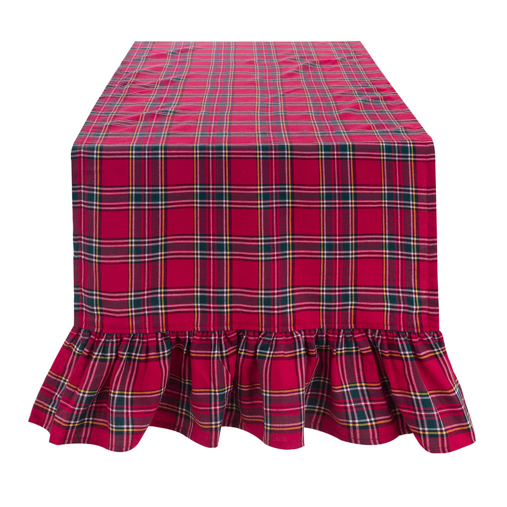 Runner natalizio Blanc Mariclò collezione Magia Tartan. Tessuto a quadri rossi e verdi con elegante gala arricciata sul bordo, steso su un tavolo su sfondo bianco neutro.