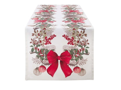 Runner da tavola Blanc Mariclò Sinfonia di Natale con stampa di agrifoglio, bacche rosse, palline e fiocco centrale. Tessuto bianco di alta qualità per tavola natalizia.