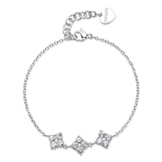 Bracciale S'Agapō della collezione Gleam in acciaio anallergico con sottile catenina a maglie, caratterizzato da tre charm centrali a forma di quadrifoglio stilizzato impreziositi da cristalli bianchi circolari e chiusura a moschettone con pendente a cuore logato.
