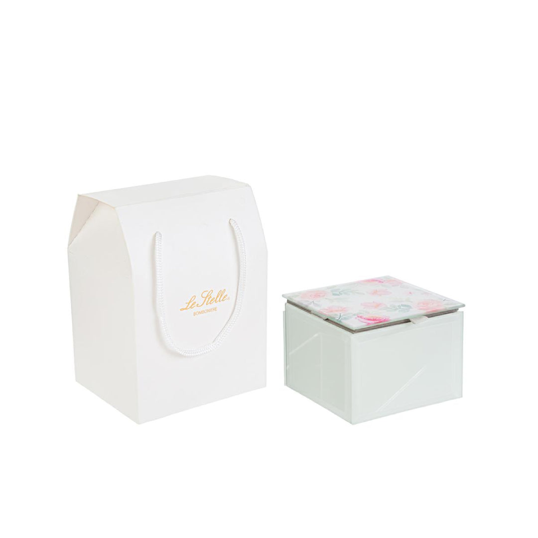Questa scatola in vetro con coperchio decorato a fiori si distingue per la forma compatta e il design elegante. Ideale come bomboniera per matrimonio, unisce stile e praticità in una soluzione raffinata. La trasparenza del vetro valorizza il contenuto, mentre la struttura resistente protegge ogni ricordo