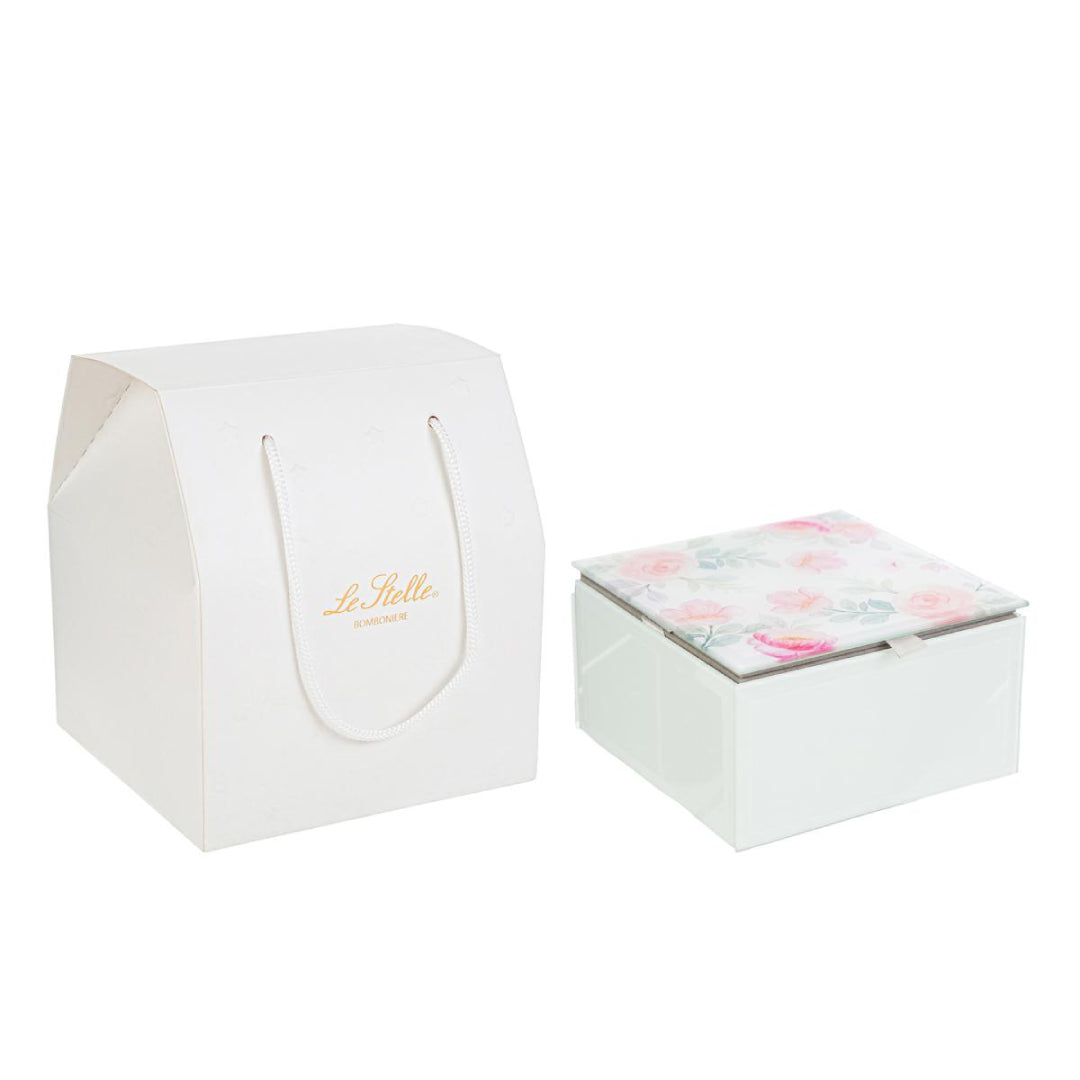 Questa scatola in vetro con coperchio decorato a fiori si distingue per la forma compatta e il design elegante. Ideale come bomboniera per matrimonio, unisce stile e praticità in una soluzione raffinata. La trasparenza del vetro valorizza il contenuto, mentre la struttura resistente protegge ogni ricordo