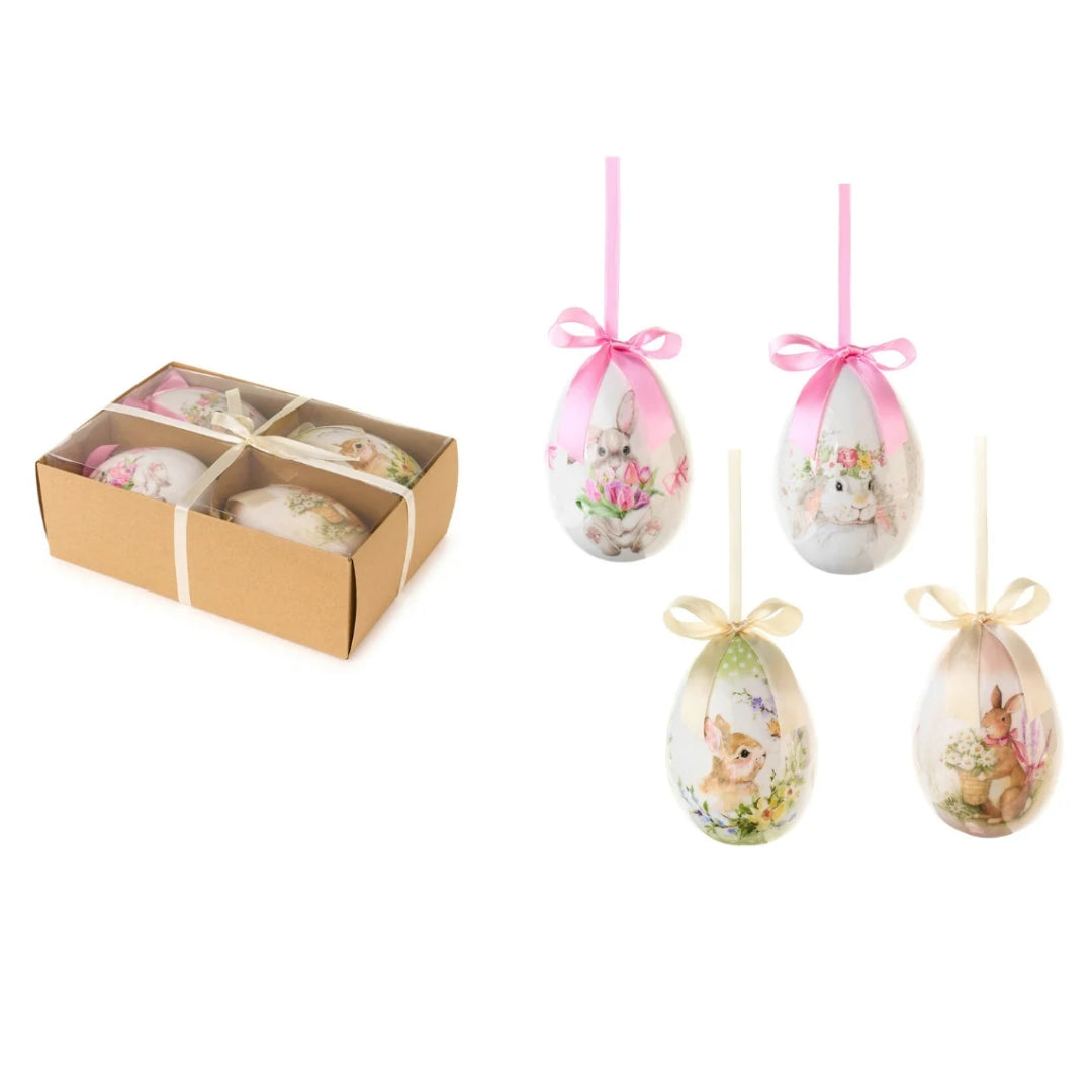 Set da 4 uova decorative della collezione "Dorothy" di Nuvole di Stoffa, pensate come addobbi pasquali da appendere per l'albero di Pasqua o per creare composizioni primaverili. Ogni uovo presenta illustrazioni in stile acquerello con teneri coniglietti, fiori, tulipani e margherite, rifinito nella parte superiore da un elegante nastro in raso con fiocco nei toni del rosa e del panna.