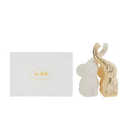Set di due elefantini decorativi in porcellana bianco e oro firmati Le Stelle, caratterizzati da una finitura lucida impreziosita da una trama geometrica a rilievo con effetto 3D e trombe sollevate che si incrociano. Queste due raffinate statuine di elefanti di design rappresentano un complemento d'arredo moderno e portafortuna, ideale come bomboniera di classe o originale oggetto ornamentale per la casa.
