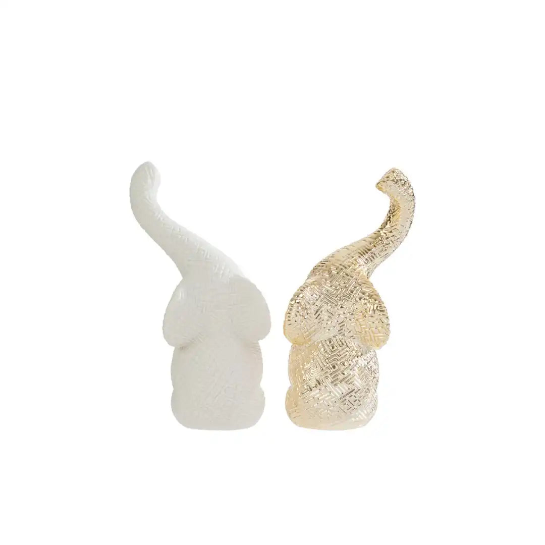 Set di due elefantini decorativi in porcellana bianco e oro firmati Le Stelle, caratterizzati da una finitura lucida impreziosita da una trama geometrica a rilievo con effetto 3D e trombe sollevate che si incrociano. Queste due raffinate statuine di elefanti di design rappresentano un complemento d'arredo moderno e portafortuna, ideale come bomboniera di classe o originale oggetto ornamentale per la casa.