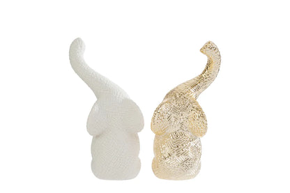 Set di due elefantini decorativi in porcellana bianco e oro firmati Le Stelle, caratterizzati da una finitura lucida impreziosita da una trama geometrica a rilievo con effetto 3D e trombe sollevate che si incrociano. Queste due raffinate statuine di elefanti di design rappresentano un complemento d'arredo moderno e portafortuna, ideale come bomboniera di classe o originale oggetto ornamentale per la casa.