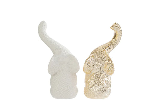 Set di due elefantini decorativi in porcellana bianco e oro firmati Le Stelle, caratterizzati da una finitura lucida impreziosita da una trama geometrica a rilievo con effetto 3D e trombe sollevate che si incrociano. Queste due raffinate statuine di elefanti di design rappresentano un complemento d'arredo moderno e portafortuna, ideale come bomboniera di classe o originale oggetto ornamentale per la casa.