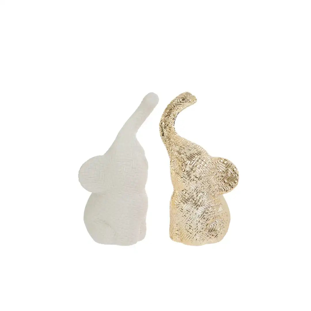 Set di due elefantini decorativi in porcellana bianco e oro firmati Le Stelle, caratterizzati da una finitura lucida impreziosita da una trama geometrica a rilievo con effetto 3D e trombe sollevate che si incrociano. Queste due raffinate statuine di elefanti di design rappresentano un complemento d'arredo moderno e portafortuna, ideale come bomboniera di classe o originale oggetto ornamentale per la casa.