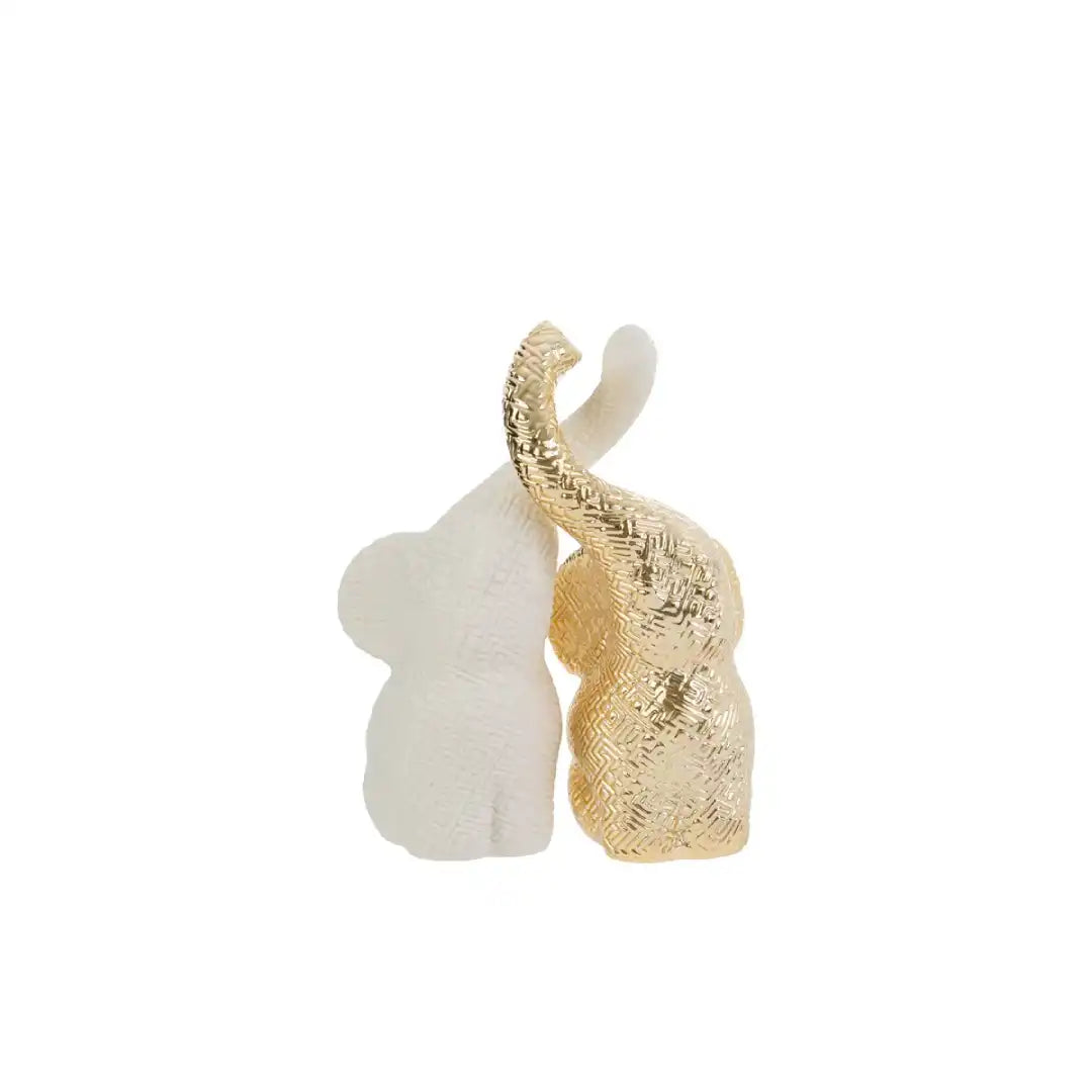Set di due elefantini decorativi in porcellana bianco e oro firmati Le Stelle, caratterizzati da una finitura lucida impreziosita da una trama geometrica a rilievo con effetto 3D e trombe sollevate che si incrociano. Queste due raffinate statuine di elefanti di design rappresentano un complemento d'arredo moderno e portafortuna, ideale come bomboniera di classe o originale oggetto ornamentale per la casa.