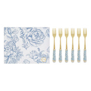 Set di 6 forchettine da dolce con decoro azzurro firmato Le Stelle, caratterizzato da rebbi in metallo color oro e raffinati manici in porcellana bianca decorati con delicati motivi floreali azzurri. Questo elegante servizio di posate da dessert di design è accompagnato dalla sua scatola regalo quadrata coordinata con la stessa fantasia botanica, perfetto come bomboniera di classe o idea regalo home decor.