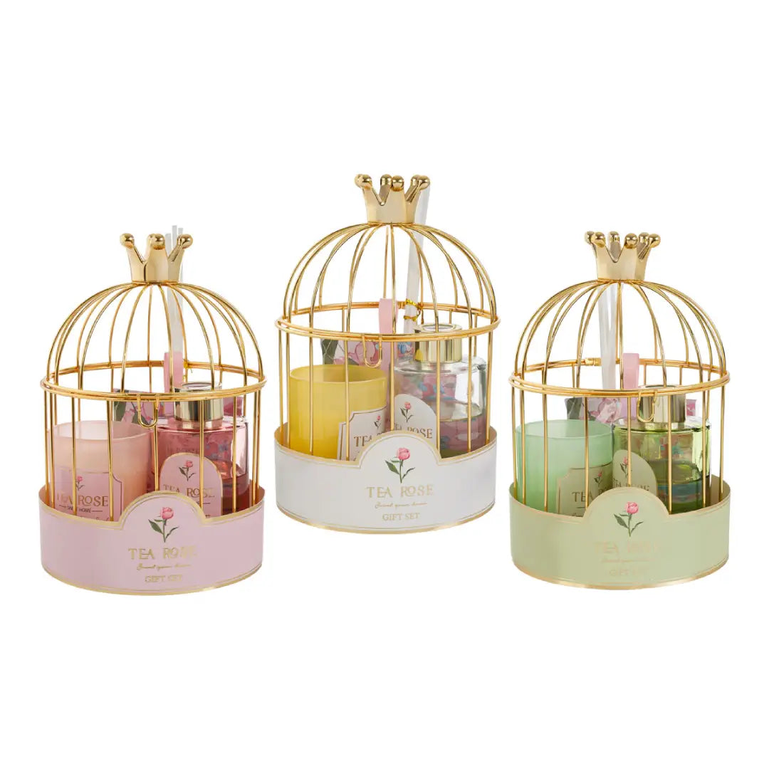 Set regalo assortito firmato Le Stelle composto da una candela in vetro e un profumatore per ambienti con bastoncini, presentati in un'elegante gabbia dorata con corona decorativa. Questa raffinata idea regalo o bomboniera per eventi è disponibile nei colori rosa, giallo e verde e include una graziosa busta shopper bianca coordinata.