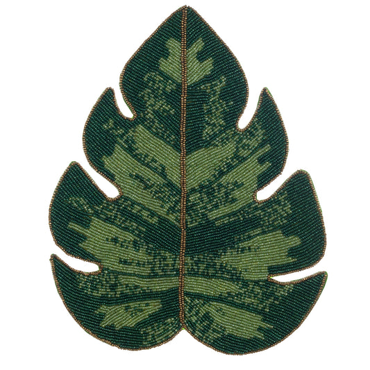 Sottopiatto decorativo Blanc Mariclò a forma di foglia di Monstera, interamente realizzato con ricami di perline in diverse sfumature di verde e venature dorate a contrasto.