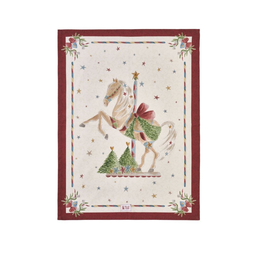 Strofinaccio natalizio in cotone Nuvole di Stoffa collezione "La Giostra di Amelie" (Modello A). Al centro, un cavallo bianco da giostra rampante con sella rossa e ghirlanda, circondato da stelline colorate e piccoli alberi di Natale su fondo panna. La cornice è rossa con decori di ghirlande agli angoli e bordi a bastoncino di zucchero.