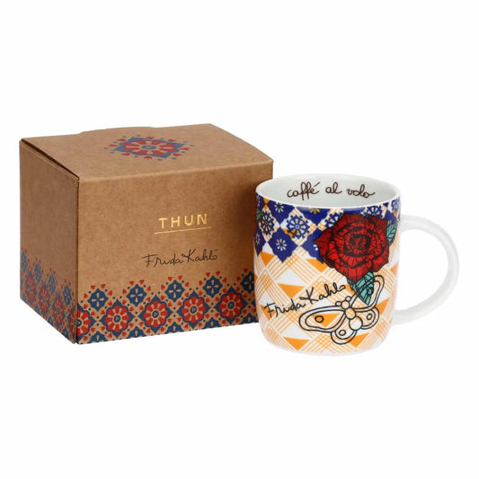 Questa mug in porcellana della collezione THUN x Frida Kahlo presenta un raffinato decoro floreale e l'illustrazione dell'iconica artista circondata da simboli della natura messicana. Il design artistico dai colori caldi e vivaci avvolge l'intera superficie, rendendo questa tazza un accessorio da cucina scenografico e ricco di personalità. Realizzata in pregiata porcellana, la mug THUN Mexico è ideale per regalare un tocco di arte e stile folk-chic alla pausa caffè quotidiana.