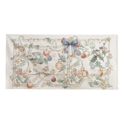 Tappeto Blanc Mariclò Intrecci di Sogni in tessuto avorio. La stampa artistica natalizia raffigura ghirlande di agrifoglio, palline colorate e un grande fiocco azzurro entro una cornice barocca.