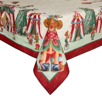 Dettaglio dell'angolo di una tovaglia natalizia in cotone Nuvole di Stoffa "Bear Wonderland". Il design presenta orsetti clown, tendoni da circo e alberi di Natale su un fondo panna, rifinito da un'ampia balza perimetrale rossa e un orsetto centrale sull'angolo che indossa un costume colorato e un cappello colorato.