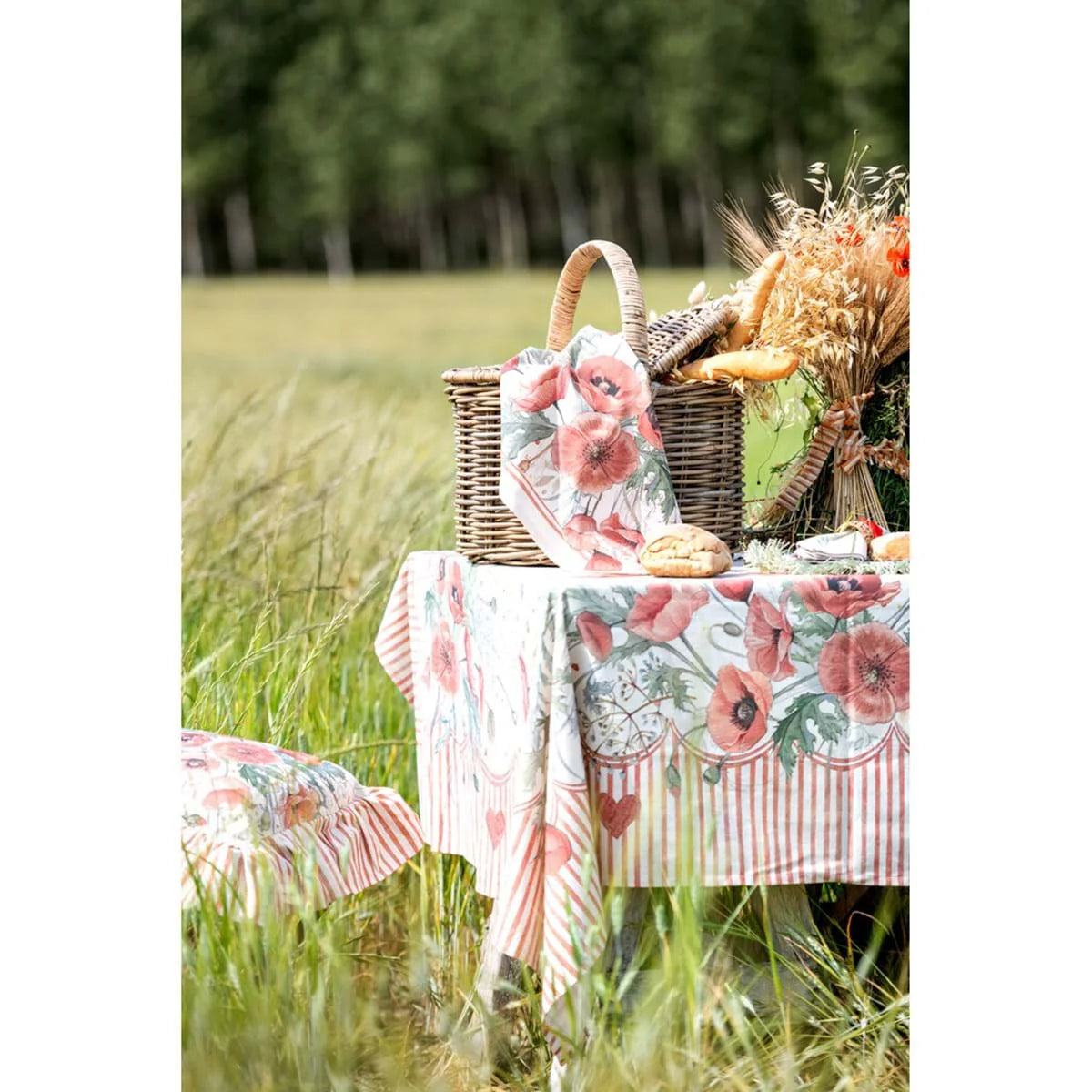 Ambientazione della tovaglia Blanc Mariclo' linea Coquelicot con stampa di papaveri rossi e boccioli. Cornice decorativa a righe verticali rosse con piccoli cuori. Design floreale elegante in stile country chic.