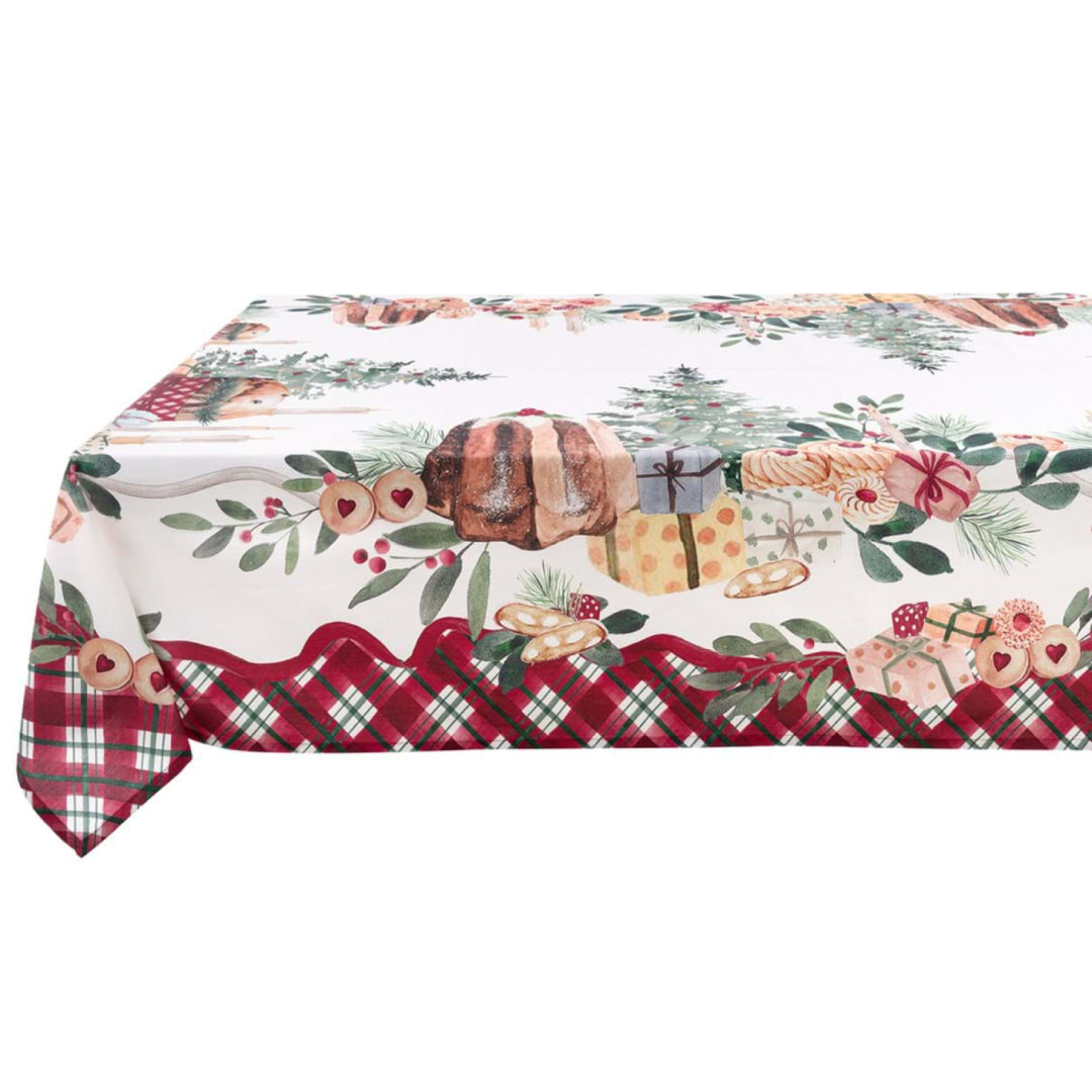 Dettaglio di una tovaglia natalizia Blanc Mariclo con bordo a balza tartan rosso. La stampa su fondo panna mostra un pandoro, pacchi regalo, biscotti e alberi di Natale in stile acquerello.