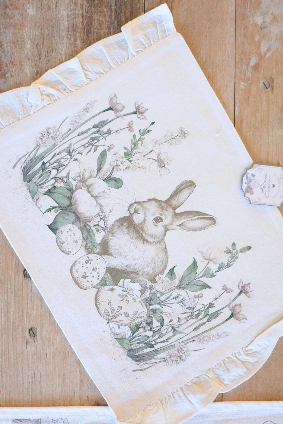 Tovaglietta con gala "Le Jardin Des Lapins" Blanc Mariclo' in stile shabby chic. Stampa delicata con coniglietti in tonalità seppia, uova decorate e fiori primaverili verdi su fondo bianco puro.