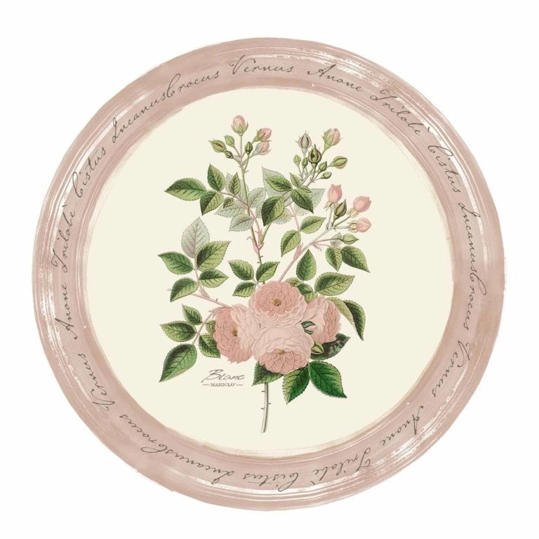Tovaglietta tonda in vinile Blanc Mariclò collezione "Le Botanique". Al centro presenta un'illustrazione botanica di rose rosa e boccioli su fondo crema, circondata da una cornice rosa antico con scritte in corsivo calligrafico.
