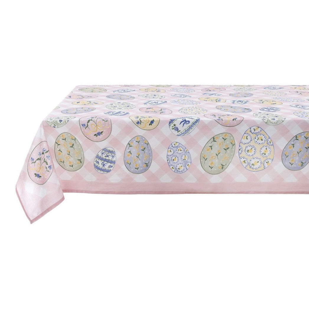 Tovaglia rettangolare della collezione "Pretty Easter" caratterizzata da una base a scacchi bianchi e rosa confetto con una balza in tinta unita sul bordo inferiore. Il tessuto è interamente stampato con uova di Pasqua decorate da motivi floreali, fiocchi gialli e trame geometriche nei toni del pastello, perfetta per apparecchiare la tavola festiva in stile shabby chic.