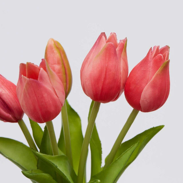 Primo piano di tulipani fuchsia in silicone che mostra la consistenza realistica dei petali e delle foglie.
