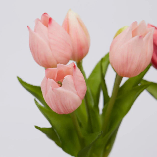Primo piano di tulipani rosain silicone che mostra la consistenza realistica dei petali e delle foglie.