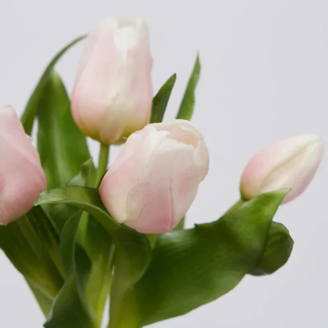 Primo piano di tulipani rosa in silicone con foglie verdi realistiche, che mostrano la consistenza materica dei petali.