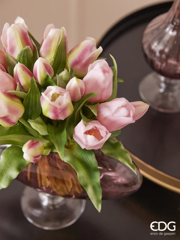 Un ricco bouquet di tulipani in silicone malva e rosa mescolati all'interno di un vaso marrone su un tavolo di design