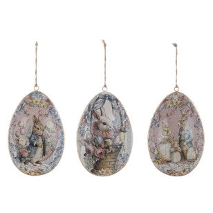 Decorazione caratterizzata da un medaglione centrale con un coniglietto vintage che indossa una giacca blu, circondato da ghirlande di rose, fiori di campo e piccoli boccioli azzurri su sfondo rosa antico.