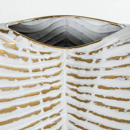 Vaso decorativo bianco e oro firmato E-Camacho, caratterizzato da una forma piatta e affusolata che riproduce fedelmente la struttura di una foglia tropicale con venature in rilievo dorate. Questo elegante complemento d'arredo di design unisce una finitura materica a un'imboccatura sottile, ideale come centrotavola ricercato o soprammobile di lusso per valorizzare interni moderni e sofisticati.