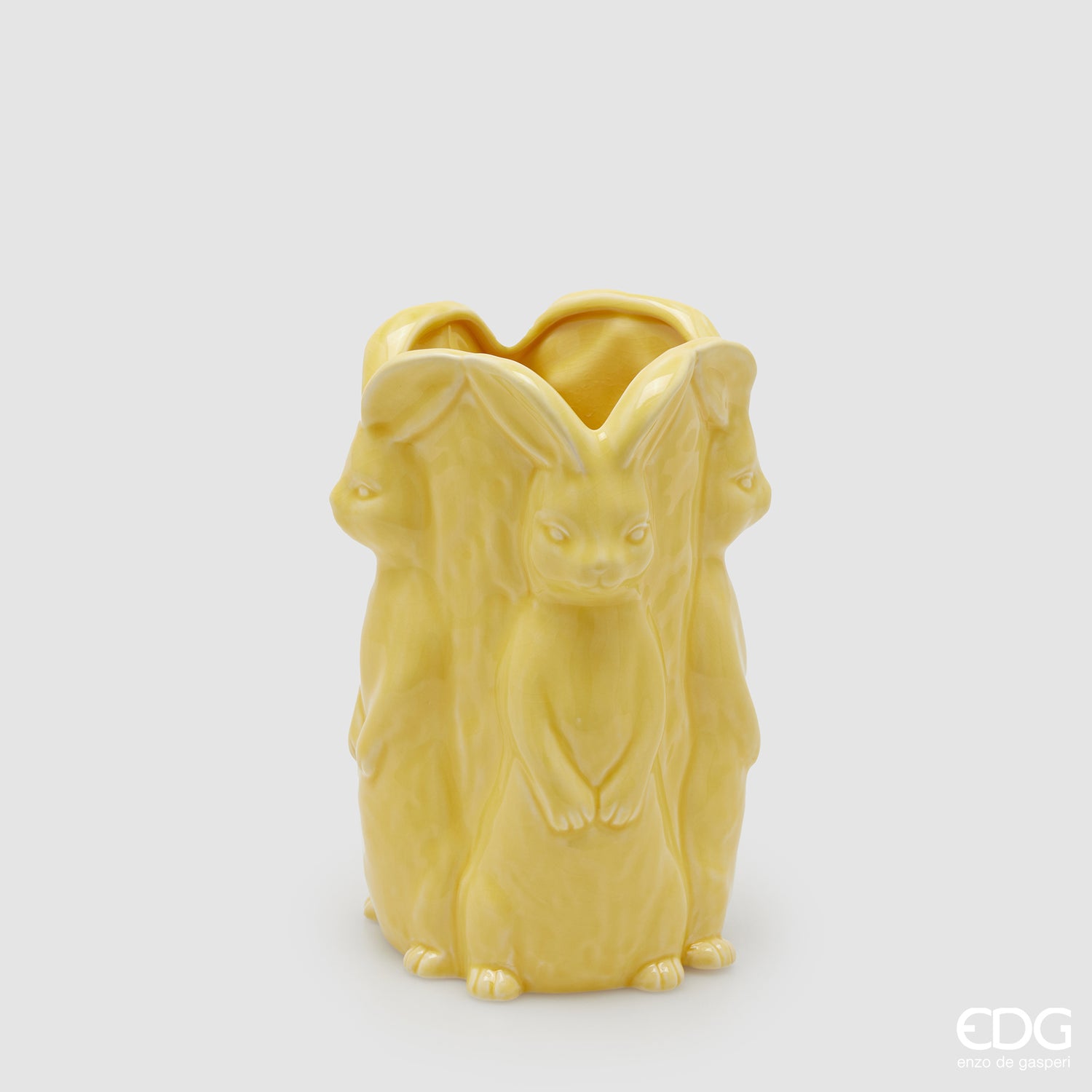 Vaso decorativo alto EDG Enzo De Gasperi linea Easter in ceramica giallo pastello. Design scultoreo composto da tre grandi conigli a figura intera che formano il corpo del vaso. Altezza 24 cm, stile elegante per la Pasqua.