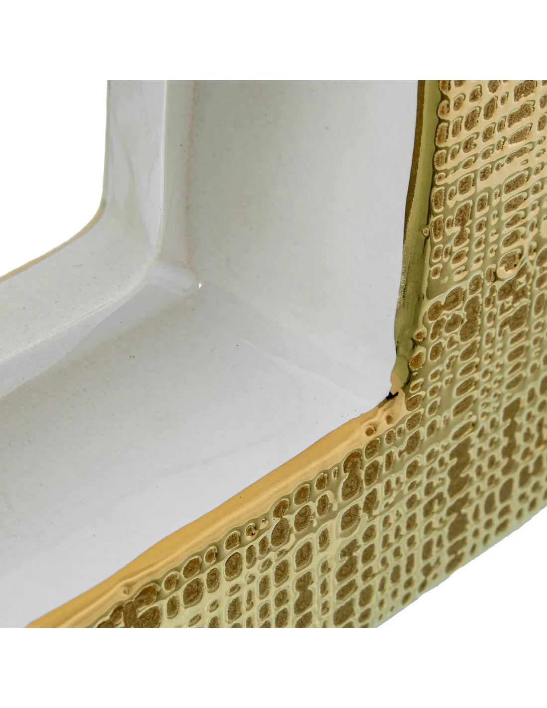 Vaso a bottiglia rettangolare orizzontale firmato Camacho, caratterizzato da un'elegante finitura ceramica color oro lucido con una texture a rilievo finemente lavorata, dettagli bianchi e un originale design geometrico con foro centrale vuoto. Questo moderno complemento d'arredo è provvisto di un collo stretto superiore ideale per ospitare singoli steli floreali, perfetto come sofisticato oggetto ornamentale per impreziosire mobili, consolle o tavoli in contesti contemporanei.