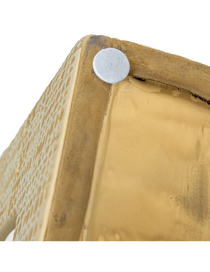 Vaso a bottiglia rettangolare orizzontale firmato Camacho, caratterizzato da un'elegante finitura ceramica color oro lucido con una texture a rilievo finemente lavorata, dettagli bianchi e un originale design geometrico con foro centrale vuoto. Questo moderno complemento d'arredo è provvisto di un collo stretto superiore ideale per ospitare singoli steli floreali, perfetto come sofisticato oggetto ornamentale per impreziosire mobili, consolle o tavoli in contesti contemporanei.