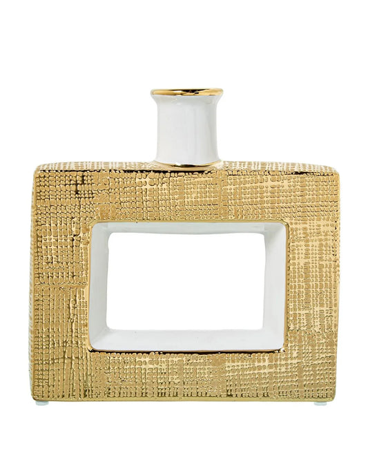 Vaso a bottiglia rettangolare orizzontale firmato Camacho, caratterizzato da un'elegante finitura ceramica color oro lucido con una texture a rilievo finemente lavorata, dettagli bianchi e un originale design geometrico con foro centrale vuoto. Questo moderno complemento d'arredo è provvisto di un collo stretto superiore ideale per ospitare singoli steli floreali, perfetto come sofisticato oggetto ornamentale per impreziosire mobili, consolle o tavoli in contesti contemporanei.