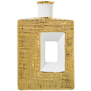 Vaso a bottiglia rettangolare verticale firmato Camacho, caratterizzato da un'elegante finitura ceramica color oro lucido con una texture a rilievo finemente lavorata, dettagli bianchi e un originale design geometrico con foro centrale vuoto. Questo moderno complemento d'arredo è provvisto di un collo stretto superiore ideale per ospitare singoli steli floreali, perfetto come sofisticato oggetto ornamentale per impreziosire mobili, consolle o tavoli in contesti contemporanei.