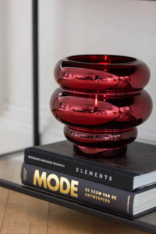 Portacandela e vaso decorativo in vetro lucido color rosso scuro modello Clea firmato Jolipa, caratterizzato da un design moderno e basso con tre sezioni sferiche sovrapposte a diametro decrescente verso la base. Questo versatile complemento d'arredo con finitura metallizzata a specchio è ideale sia come portacandele d'atmosfera sia come piccolo vaso o centrotavola di design per ambienti eleganti e contemporanei.